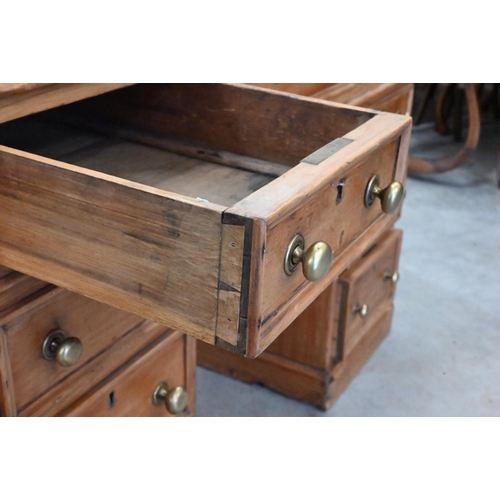 89 - An early 20th century small pine twin pedestal desk with tooled green leather top over nine drawers,... 