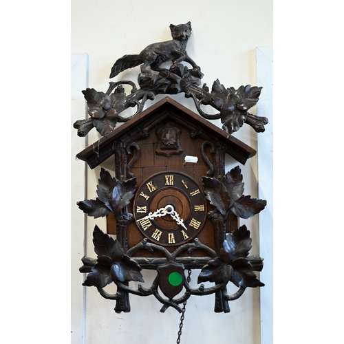 558 - A 20th century Black Forest style carved oak twin-weight cuckoo clock surmounted by a fox crest c/w ... 