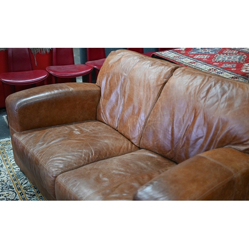 560 - A modern antiqued tan leather three seater sofa to/with a matching two seat sofa, an armchair and ot... 