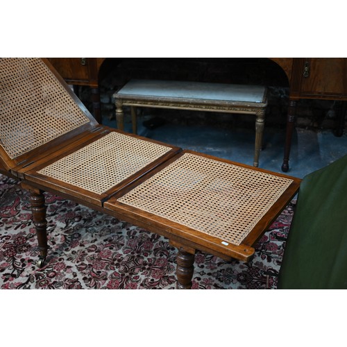 32 - A Victorian cane panelled campaign day bed, raised on turned legs to brass castors, with green leath... 