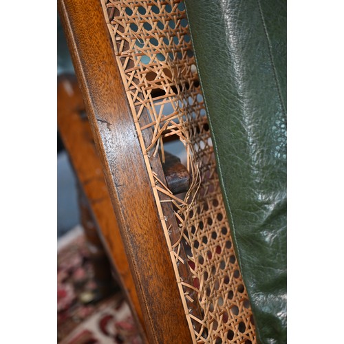 32 - A Victorian cane panelled campaign day bed, raised on turned legs to brass castors, with green leath... 