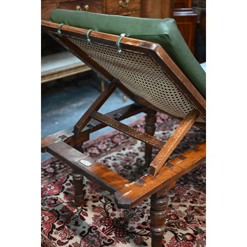 32 - A Victorian cane panelled campaign day bed, raised on turned legs to brass castors, with green leath... 