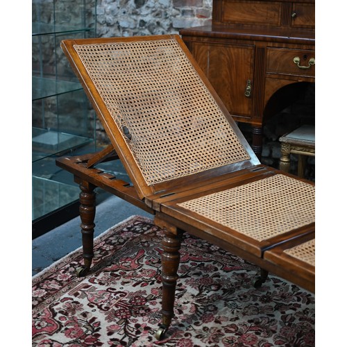 32 - A Victorian cane panelled campaign day bed, raised on turned legs to brass castors, with green leath... 