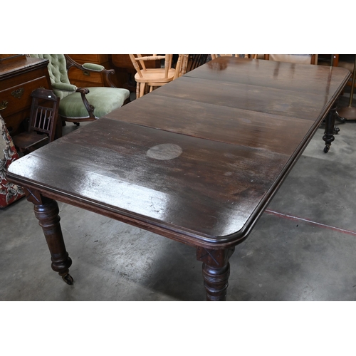 184 - A late Victorian mahogany extending wind-out action dining table with two central leaves and ring tu... 