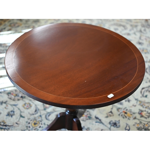 117 - A reproduction mahogany and rosewood banded oval occasional table with central inlaid fan patera, 58... 