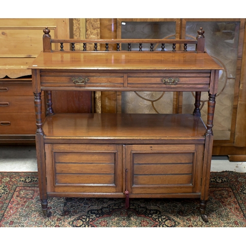 153 - An Edwardian mahogany buffet with two drawers and panelled cupboard doors on turned legs and casters... 