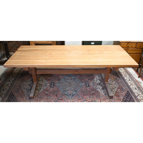 181 - A rectangular pitch pine refectory dining table on twin square pad supports united by pegged stretch... 