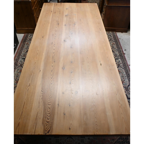 181 - A rectangular pitch pine refectory dining table on twin square pad supports united by pegged stretch... 