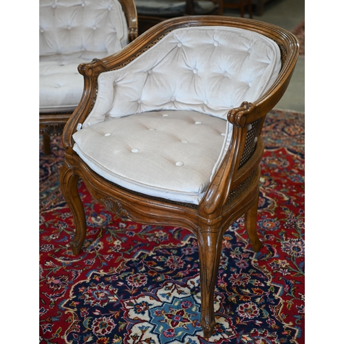 200 - A pair of French carved walnut bergere salon chairs in the Louis XV style, with champagne buttoned f... 