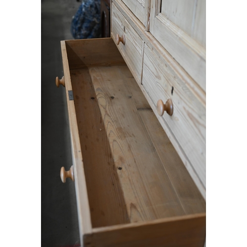 217 - Antique stripped pine linen press with dentil moulded cornice over twin panelled doors enclosing sli... 