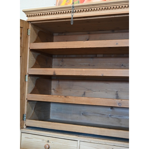 217 - Antique stripped pine linen press with dentil moulded cornice over twin panelled doors enclosing sli... 