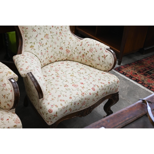 221 - A pair of Victorian floral carved mahogany armchairs upholstered in scrolling floral fabric