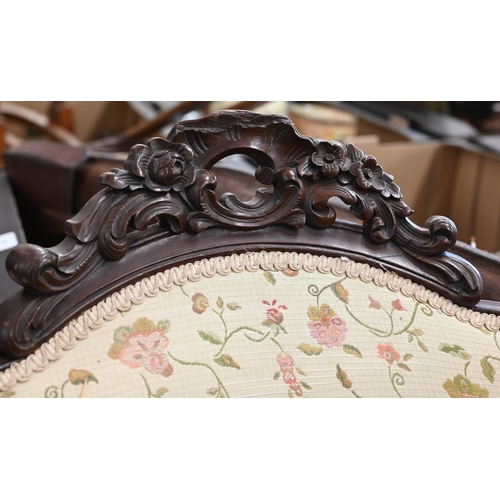 221 - A pair of Victorian floral carved mahogany armchairs upholstered in scrolling floral fabric