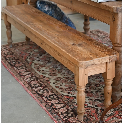 235 - A rustic stained pine bench on turned supports, 184 x 30 x 46 cm h