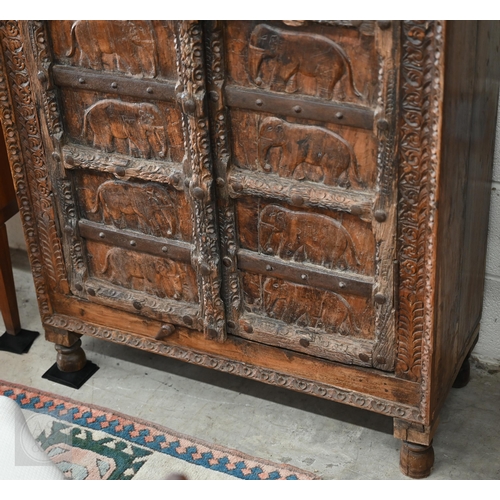 253 - Indian stained hardwood 'Havali' cupboard profusely carved with foliate designs around the frame and... 