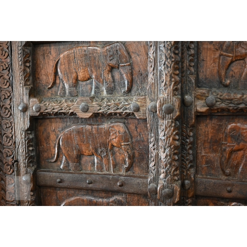 253 - Indian stained hardwood 'Havali' cupboard profusely carved with foliate designs around the frame and... 