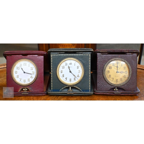 266 - A trio of vintage leather cased travel clocks, 8-day Swiss movements to/with three miniature travel ... 