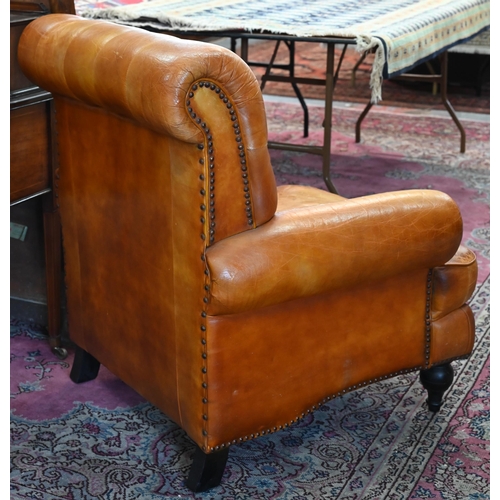 268 - A Victorian style tan leather button backed armchair, raised on turned front legs, uneven colour fad... 