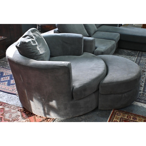 269 - A large circular revolving loveseat armchair and matching crescent form stool, in grey fabric by DFS... 