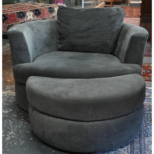 269 - A large circular revolving loveseat armchair and matching crescent form stool, in grey fabric by DFS... 