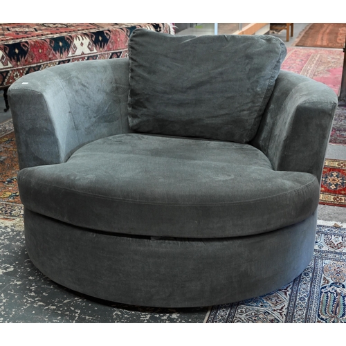 269 - A large circular revolving loveseat armchair and matching crescent form stool, in grey fabric by DFS... 