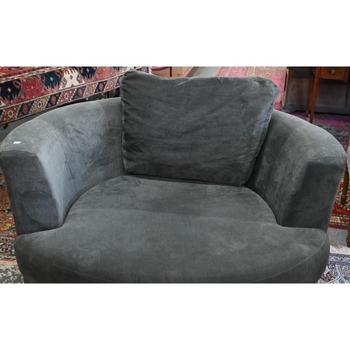 269 - A large circular revolving loveseat armchair and matching crescent form stool, in grey fabric by DFS... 