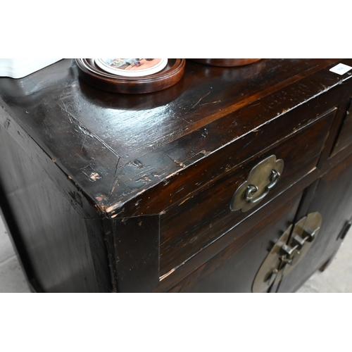 30 - An old Chinese stained hardwood and brass mounted cabinet, with two drawers over cupboard doors, 90 ... 