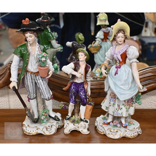 402 - A pair of Sitzendorf figures, a couple gardening, 23.5 cm high to/w a grape-picker, 17.5 cm high (3)