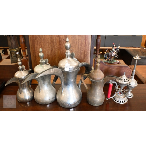 469 - A graduated set of three Arabic dallah coffee pots, to/w a copper example, a rosewater flask and an ... 