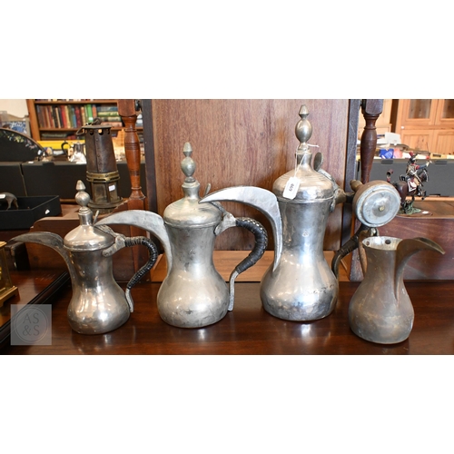 469 - A graduated set of three Arabic dallah coffee pots, to/w a copper example, a rosewater flask and an ... 