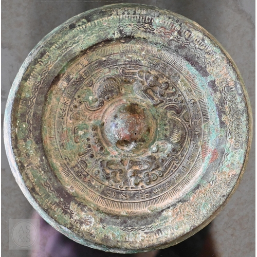 470 - A Japanese bronze circular mirror of traditional form, embossed with dragons, 12.5 cm diameter