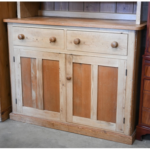 69 - A vintage pine dresser with glazed doors enclosing two shelves, on a cabinet base with two drawers o... 