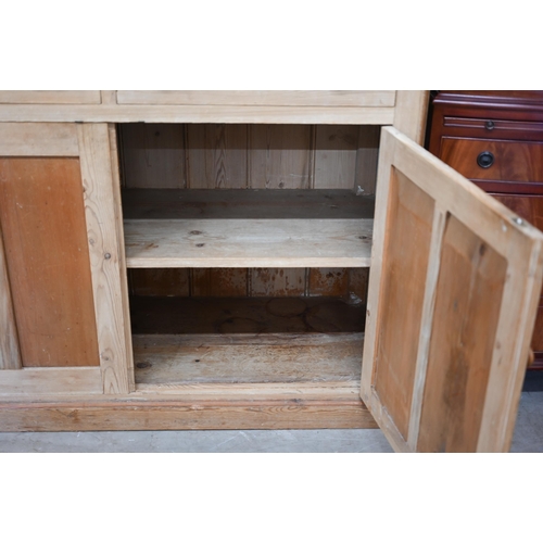 69 - A vintage pine dresser with glazed doors enclosing two shelves, on a cabinet base with two drawers o... 