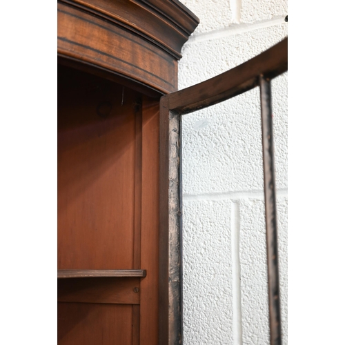 71 - An Edwardian mahogany barrel-front corner cabinet with glazed doors enclosing shelves on cabinet bas... 