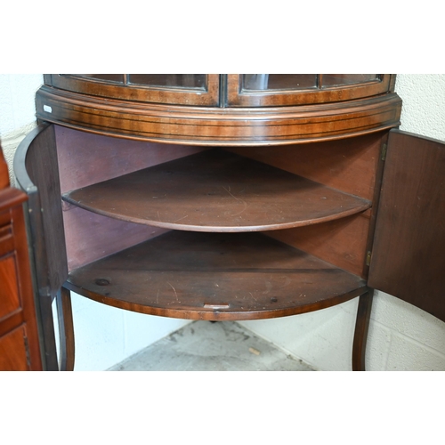 71 - An Edwardian mahogany barrel-front corner cabinet with glazed doors enclosing shelves on cabinet bas... 