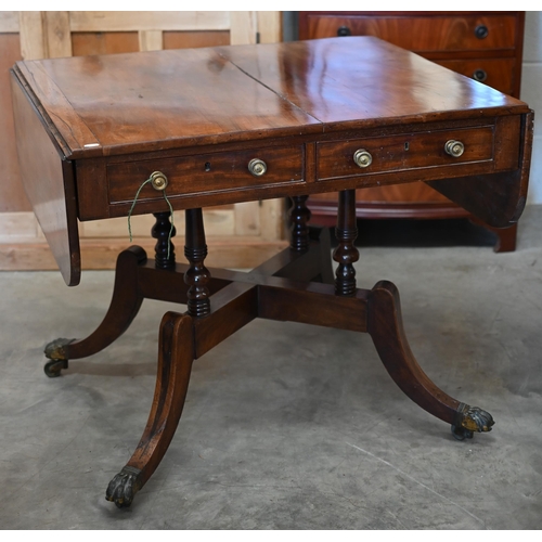 72 - A Regency mahogany sofa table with two drawers and quadraform base with turned pillars and out-swept... 