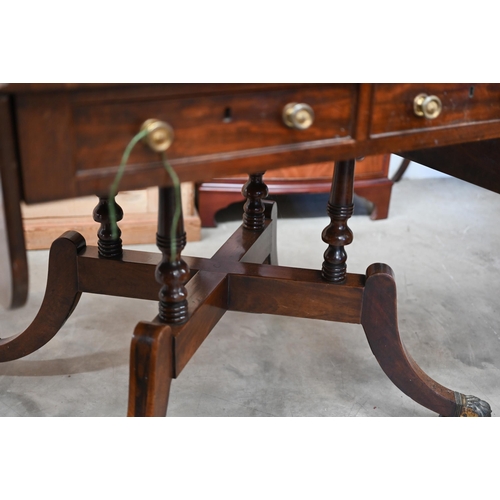 72 - A Regency mahogany sofa table with two drawers and quadraform base with turned pillars and out-swept... 