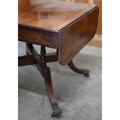 72 - A Regency mahogany sofa table with two drawers and quadraform base with turned pillars and out-swept... 