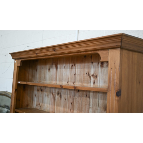 77 - A stained pine open bookcase with moulded cornice and five fixed shelves, 142 cm w x 30 cm d x 186 c... 