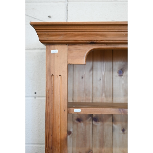 77 - A stained pine open bookcase with moulded cornice and five fixed shelves, 142 cm w x 30 cm d x 186 c... 