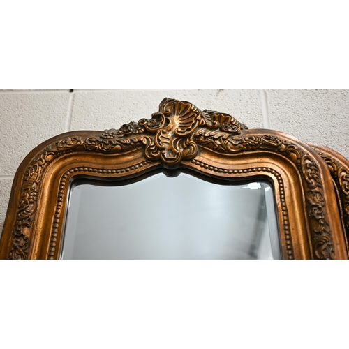 82 - A pair of Rococo style bevelled mirrors in giltwood and composite moulded foliate frames with shell ... 