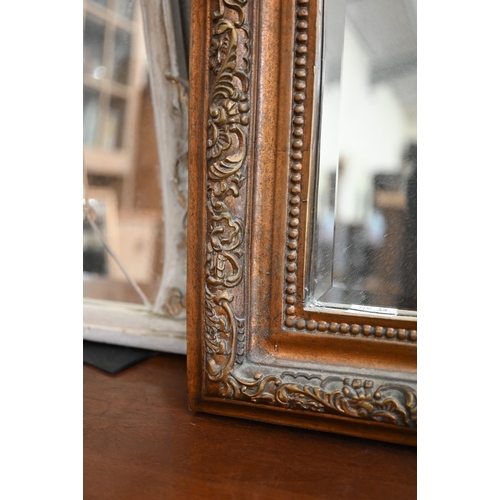 82 - A pair of Rococo style bevelled mirrors in giltwood and composite moulded foliate frames with shell ... 