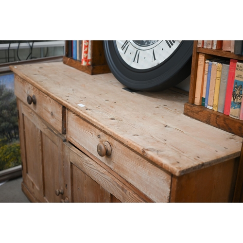 90 - An antique pine dresser base with two drawers over panelled cupboard doors, 158 cm w x 64 cm d x 92 ... 