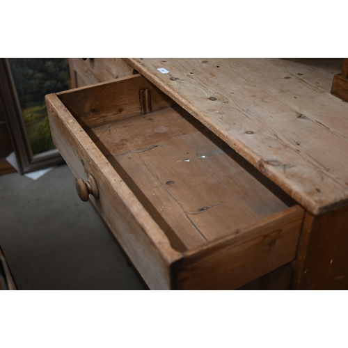 90 - An antique pine dresser base with two drawers over panelled cupboard doors, 158 cm w x 64 cm d x 92 ... 