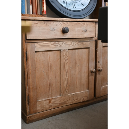 90 - An antique pine dresser base with two drawers over panelled cupboard doors, 158 cm w x 64 cm d x 92 ... 