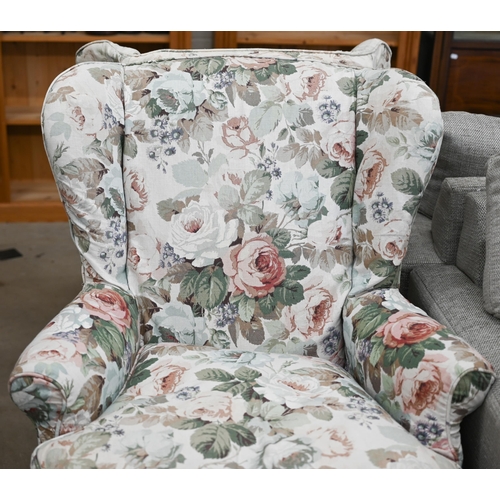 93 - A pair of mahogany framed wingback armchairs with loose floral covers and cabriole front legs