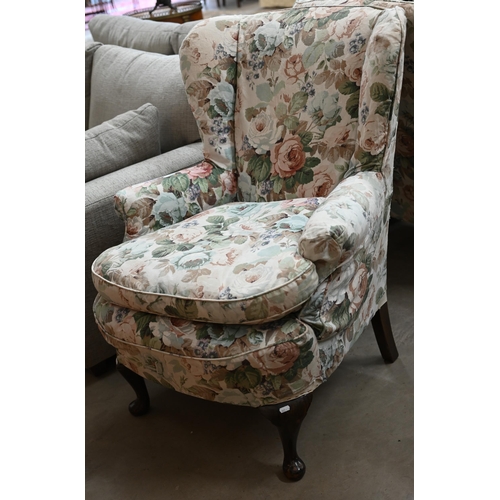 93 - A pair of mahogany framed wingback armchairs with loose floral covers and cabriole front legs