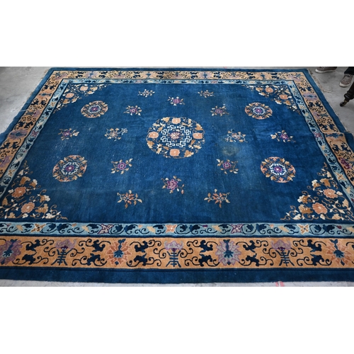 128 - A Mid-Century Chinese Peking carpet, scattered design with floral sprays and roundels on blue ground... 