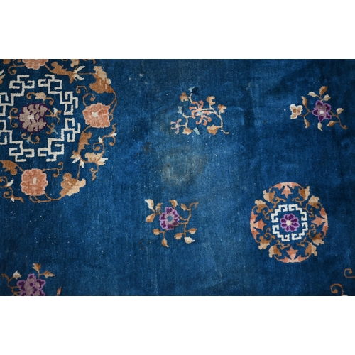 128 - A Mid-Century Chinese Peking carpet, scattered design with floral sprays and roundels on blue ground... 