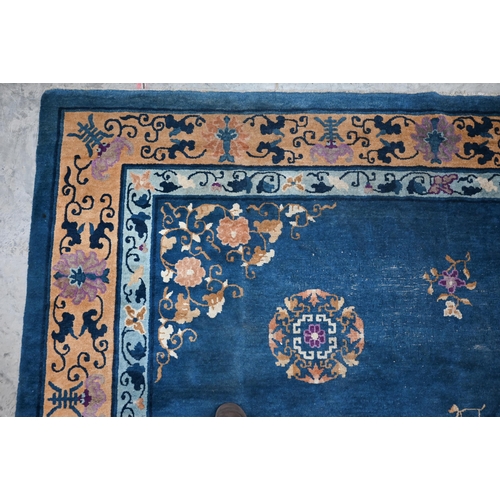 128 - A Mid-Century Chinese Peking carpet, scattered design with floral sprays and roundels on blue ground... 